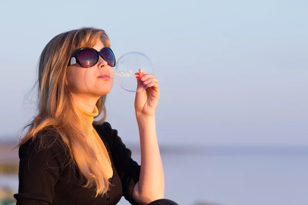 Jong meisje in zonnebril zeepbellen blazen — Stockfoto