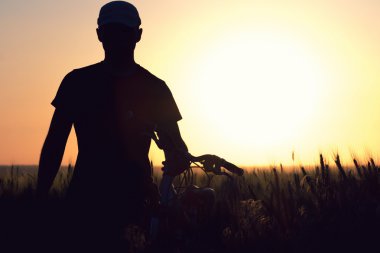 bir bisiklet bir tarlada olarak genç bir adam