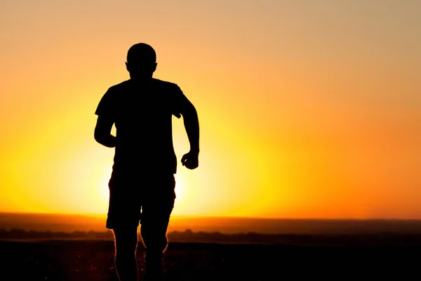 Un giovane che corre sul campo — Foto Stock