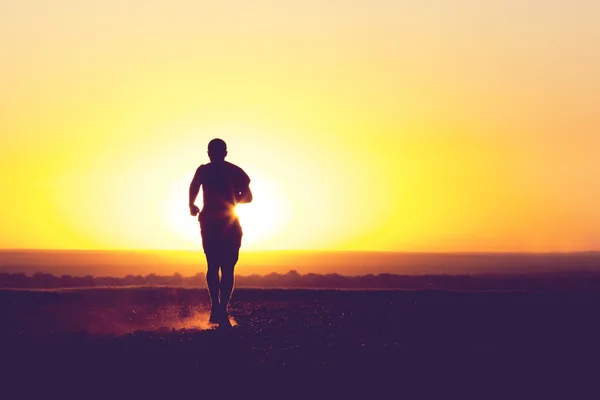 Un giovane che corre sul campo — Foto Stock