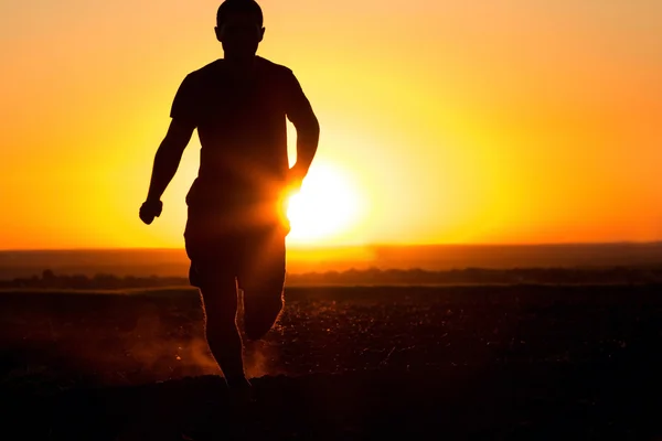 Silhouette uomo in esecuzione sul campo — Foto Stock