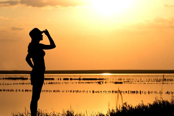 Junges Mädchen bei Sonnenuntergang auf dem Meer — Stockfoto