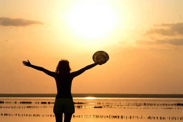 Silhouette eines jungen Mädchens auf dem Meer mit Hut — Stockfoto