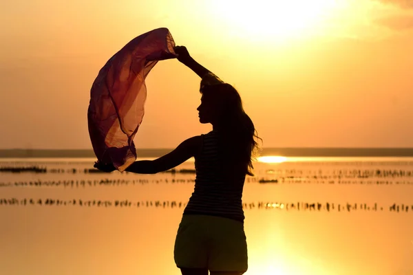 Chica joven al atardecer en el mar —  Fotos de Stock