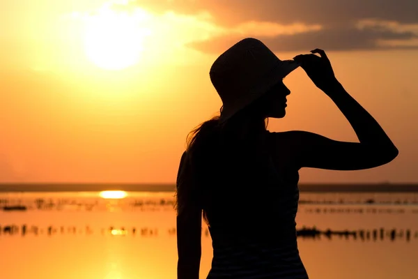 Silhouette of a young girl on the background of the sea — Stock Photo, Image