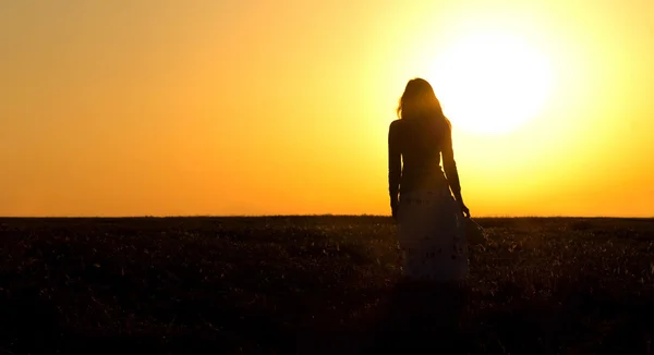 Silhouette of a girl in field with ears — Stock Photo, Image