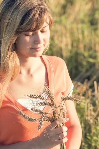 Jeune belle fille dans le domaine avec des oreilles dans la main — Photo