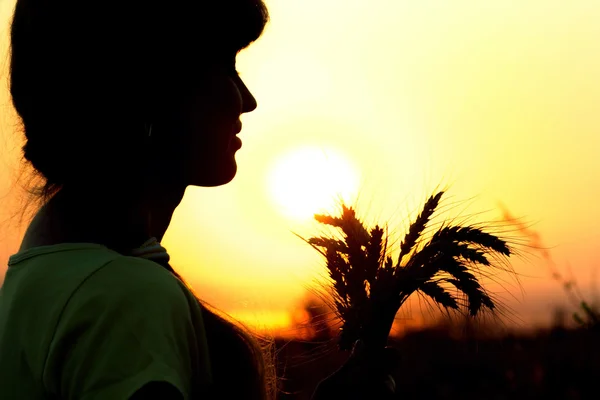 Silhouette eines Mädchens im Feld mit Ohren — Stockfoto