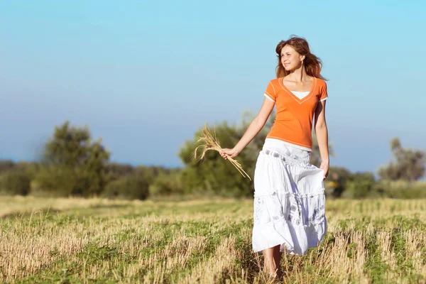 Joven hermosa chica en el campo con orejas en la mano — Foto de Stock