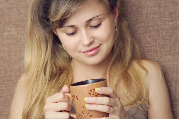 Vacker flicka dricker en drink från en kopp — Stockfoto