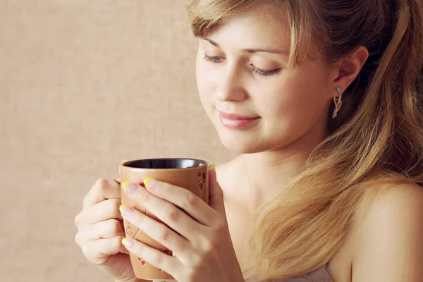 Vacker flicka dricker en drink från en kopp — Stockfoto