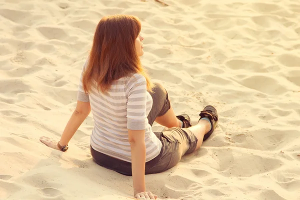 Menina está descansando sentado na areia — Fotografia de Stock