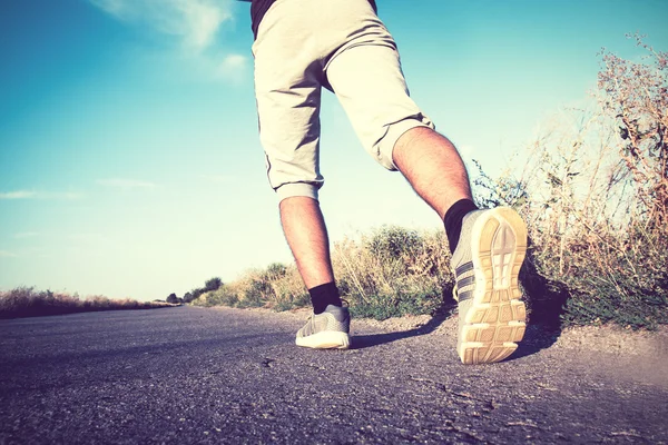 Gambe di corsa dell'uomo sulla strada asfaltata — Foto Stock