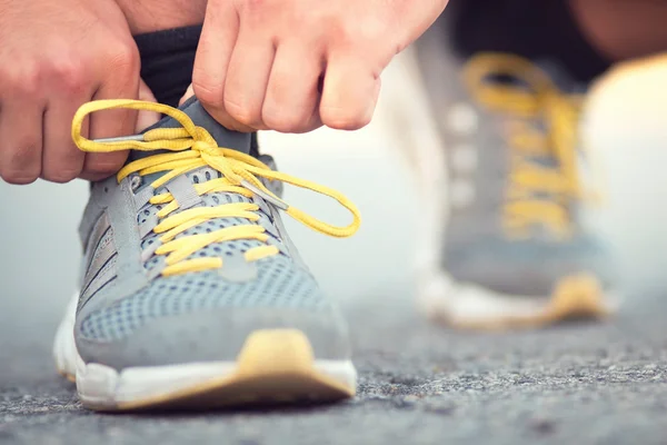 Corredor atando cordones en zapatillas — Foto de Stock