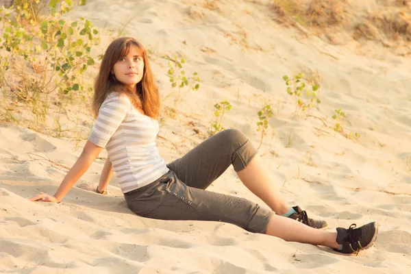 Girl is resting sitting on the sand — Stock Photo, Image