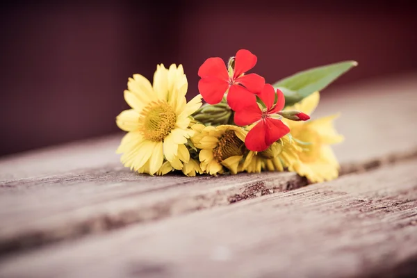Bloemen liggend op een houten bench — Stockfoto