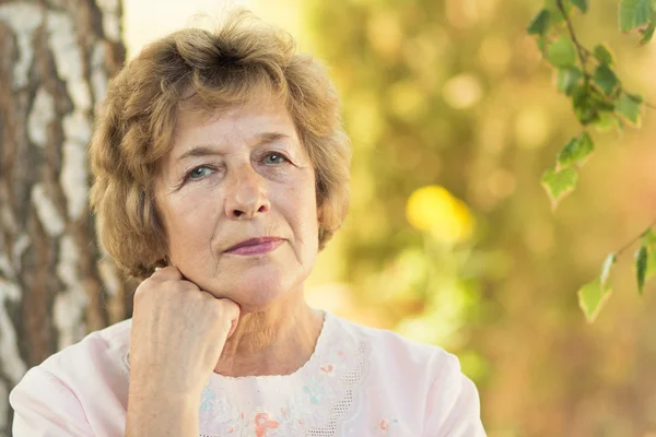 Portret van een bejaarde vrouw in de natuur — Stockfoto