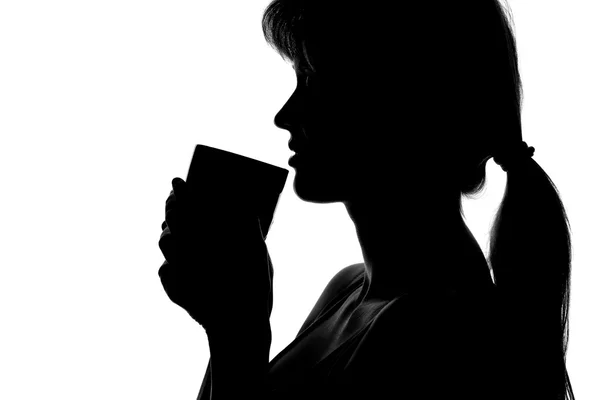 手にカップを持つ女性のシルエット — ストック写真