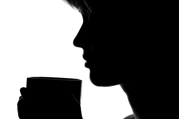 Silhouette of a woman with a cup in hands — Stock Photo, Image