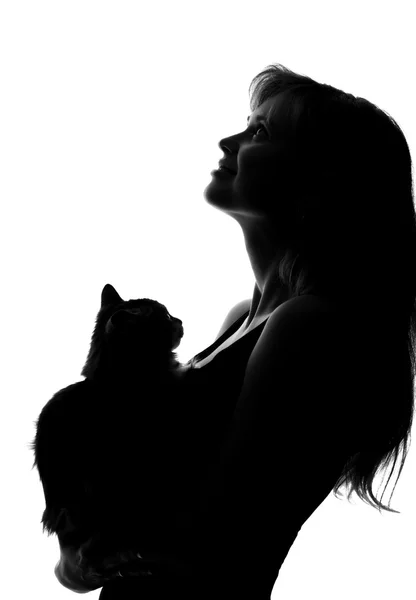 Silhouet van een vrouw met een kat in haar armen — Stockfoto