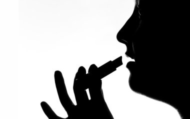 Kız dudaklarını rujla boyuyor.