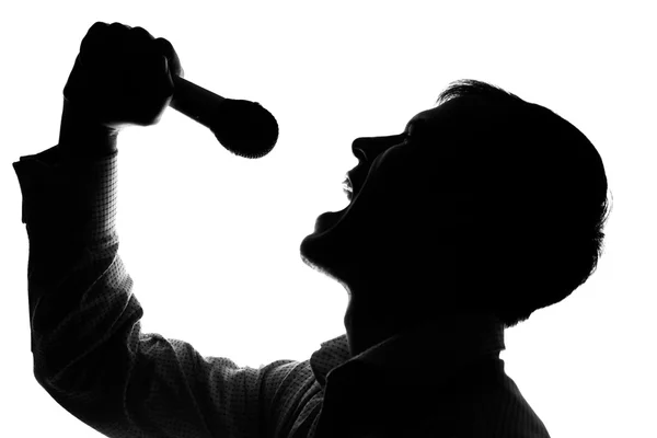 Um jovem cantando em um microfone — Fotografia de Stock