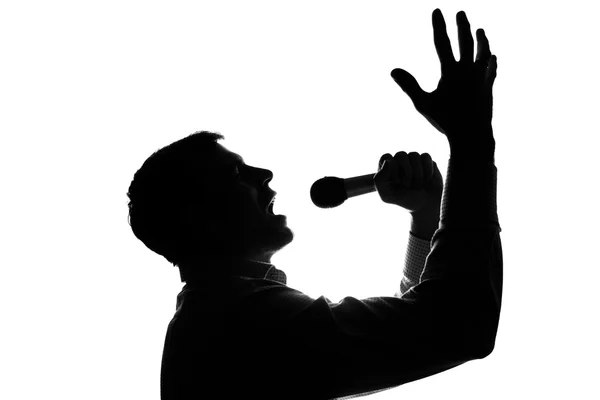 Молодий чоловік співає в мікрофон, піднімаючи руки — стокове фото