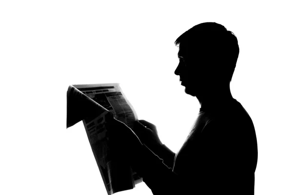 Молодой человек читает книгу - силуэт — стоковое фото