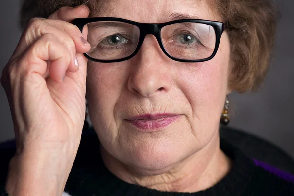 Portret van een mooie oudere vrouw met glazen — Stockfoto