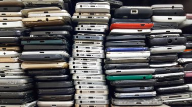 Hasarlı cep telefonlarının geçmişi. Bir sürü bozuk akıllı telefon. Kullanılmış telefonlar üst üste yığılmış. Onarım hizmetleri ve ekipman bakımı.