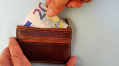Parmakları cüzdanından yirmi avro çekiyor. Masraflar ve gelir. Mağazadan alışveriş..