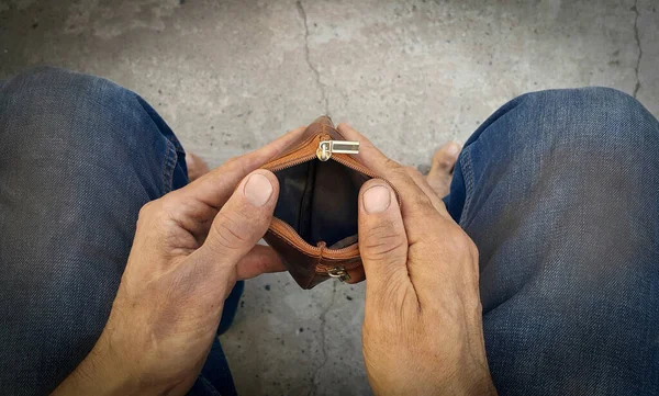 Cüzdanı boş, evsiz, zavallı bir adamın kirli elleri. İşsiz bir adam. Kuruluşun iflası. Yoksulluk ve sefalet. İhtiyacı olan vatandaşlar. Açlık ve soğuk. Odaklanmadan çıplak ayaklar.