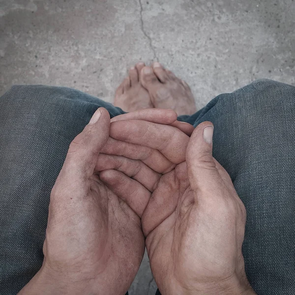 Begging. Outstretched hands. Barefoot. A homeless person. Diminution of money. Poor man. A beggar in the transition. An unemployed citizen. There is no work. Dirty hands and feet. Stink and dirt.