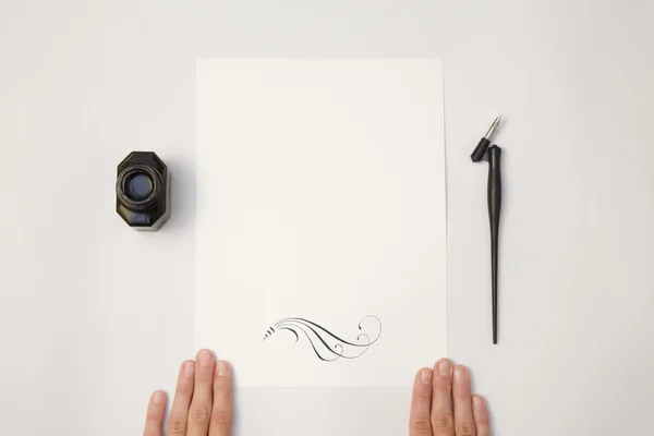 Mano tenendo bianco foglio di carta bianco mockup Immagine Stock