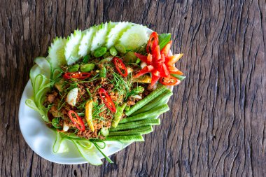 Tayland yemeği, ton balığı ve fesleğenle kızartılmış (Pad Ka Prao ton balığı) ahşap arka planda, ev yapımı yemek.