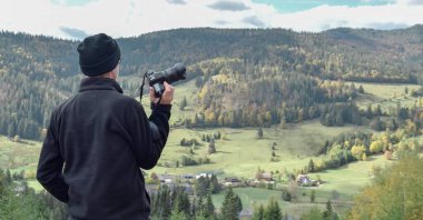 Dağda kameralı bir fotoğrafçı var.