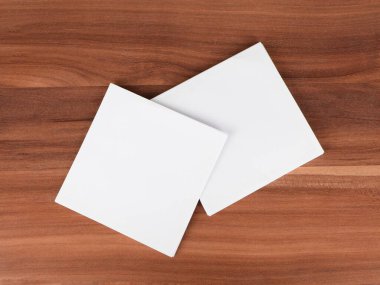 Ahşap arkaplanda boş beyaz kağıt kağıtlar.