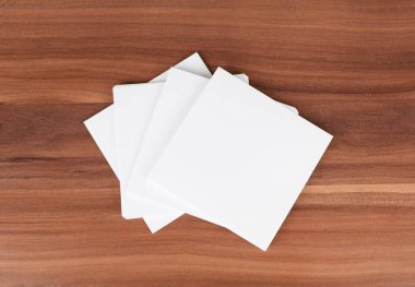 Ahşap arkaplanda boş beyaz kağıt kağıtlar.