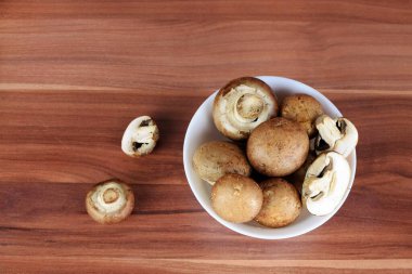 Beyaz arka planda beyaz kasede taze mantarlar.