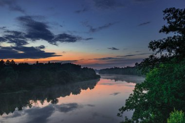 Akşam sisi, nehrin üzerinde gün batımında 