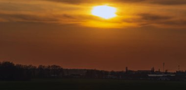 sunset over a field and agricultural area 