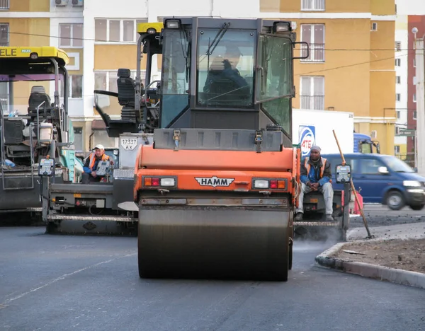 ウクライナ、ハリコフ、 2020年10月27日。労働者とアスファルトマシンのクローズアップビュー。街の道路のアスファルトや修理のローラーや労働者 — ストック写真