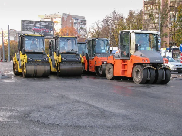 Ucrania, Kharkiv, 27 de octubre de 2020. Vista de cerca de los trabajadores y las máquinas de asfaltado. Rodillo y trabajadores sobre asfalto y reparación de calles de la ciudad —  Fotos de Stock