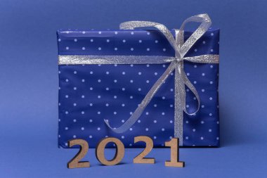 Mavi kağıda sarılı hediyeli bir kutu. Mavi arka planda gümüş kurdeleli puantiyeli. Yazıt 2021. Noel hediyesi, yeni yıl, sevgililer günü ya da yıldönümü. Yüksek kalite fotoğraf