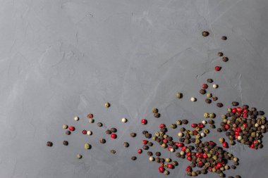 Biber karışımı. Siyah, kırmızı ve beyaz biberler siyah taş arka planda izole edilmiş. Yakın çekim, üst görünüm, boşluğu kopyala