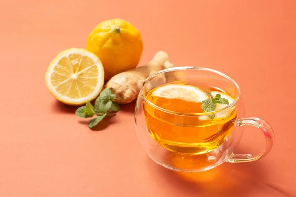 Naneli ve limonlu zencefilli çay. Sağlıklı bir içki. Parlak arka planda kristal bardak. Seçici odak.