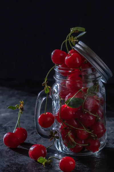 Cereza dulce en una copa sobre fondo negro. Frutas jugosas, bajo perfil, primer plano. — Foto de Stock