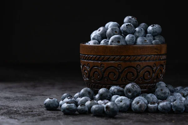 Fresh juicy blueberries in the bowl on the black background. Low key photography — Stock Photo, Image