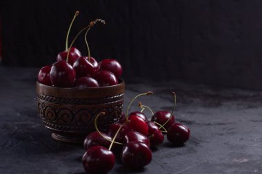 Arka planda bir kasede organik sulu kiraz. Yakın plan fotoğraf, sade tuş