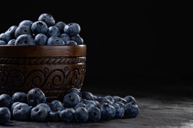 Siyah arka plandaki kasede taze, sulu yaban mersini. Gösterişsiz fotoğrafçılık. Yüksek kalite fotoğraf